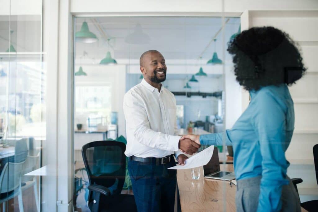 CHRO shaking hands with a colleague, highlighting successful leadership and human resources strategy.