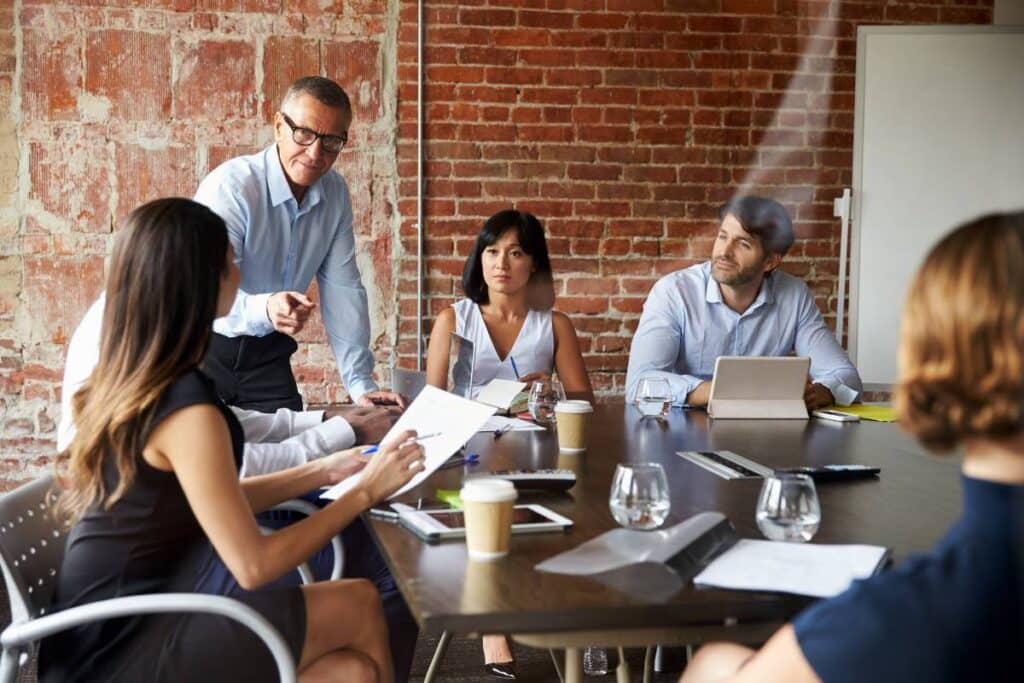 A business meeting where team members discuss the importance of emotional intelligence in investing decisions.