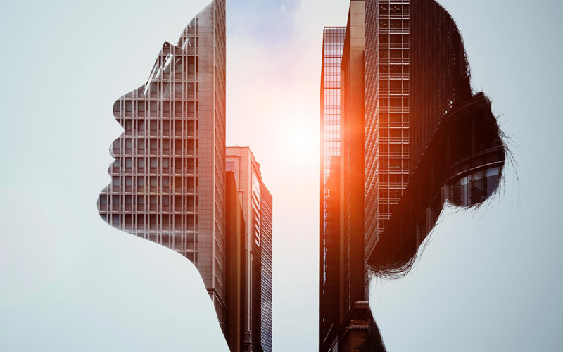 Stylized image of a woman's head with buildings flling her profile.